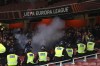 Angry PSVs fans are seen through a smoke after the end of the Europa League soccer match between Arsenal and PSV at Emirates stadium in London, Thursday, Oct. 20, 2022. (AP Photo/Ian Walton)