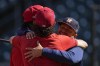 Philadelphia Phillies second baseman Jean Segura, left, and Philadelphia Phillies catcher Garrett Stubbs, center, embrace Houston Astros Javier Bracamonte ahead of Game 1 of the baseball World Series between the Houston Astros and the Philadelphia Phillies on Thursday, Oct. 27, 2022, in Houston. Game 1 of the series starts Friday. (AP Photo/Eric Gay)