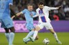 PSG's Lionel Messi, right, is challenged by Troyes' Ante Palaversa during the French League One soccer match between Paris Saint-Germain and Troyes at the Parc des Princes in Paris, France, Saturday, Oct. 29, 2022. (AP Photo/Francois Mori)