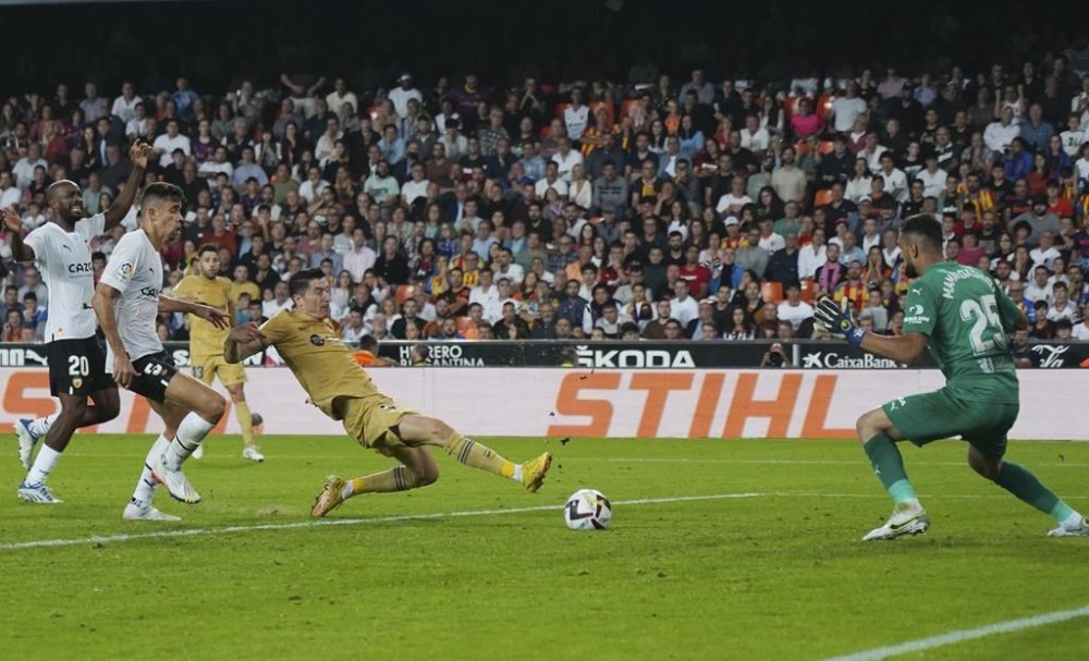 Barcelona's Robert Lewandowski scores the opening goal in extra time during a Spanish La Liga soccer match between Valencia and Barcelona at the Mestalla stadium in Valencia, Spain, Saturday, Oct. 29, 2022. (AP Photo/Alberto Saiz)