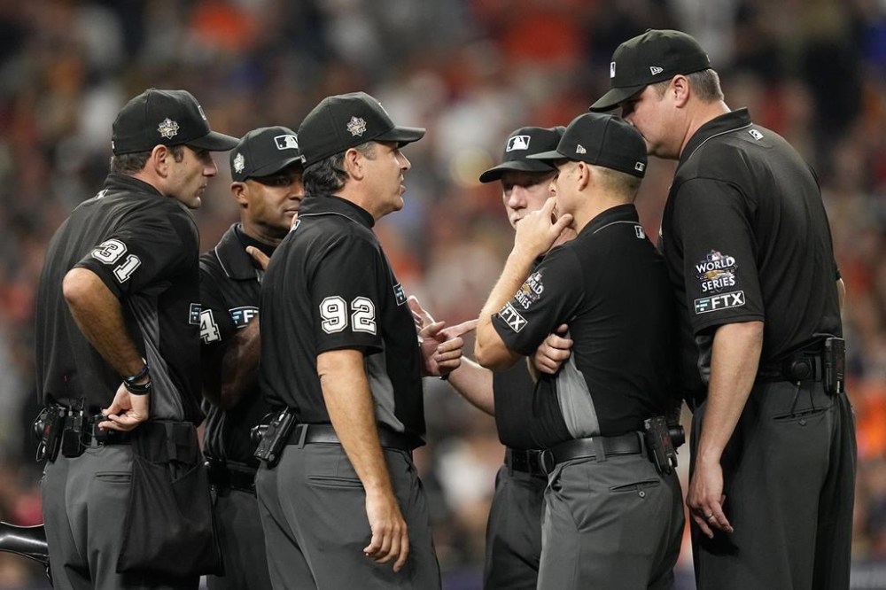 Officials confer during the fifth inning in Game 2 of baseball's World Series between the Houston Astros and the Philadelphia Phillies on Saturday, Oct. 29, 2022, in Houston. (AP Photo/David J. Phillip)