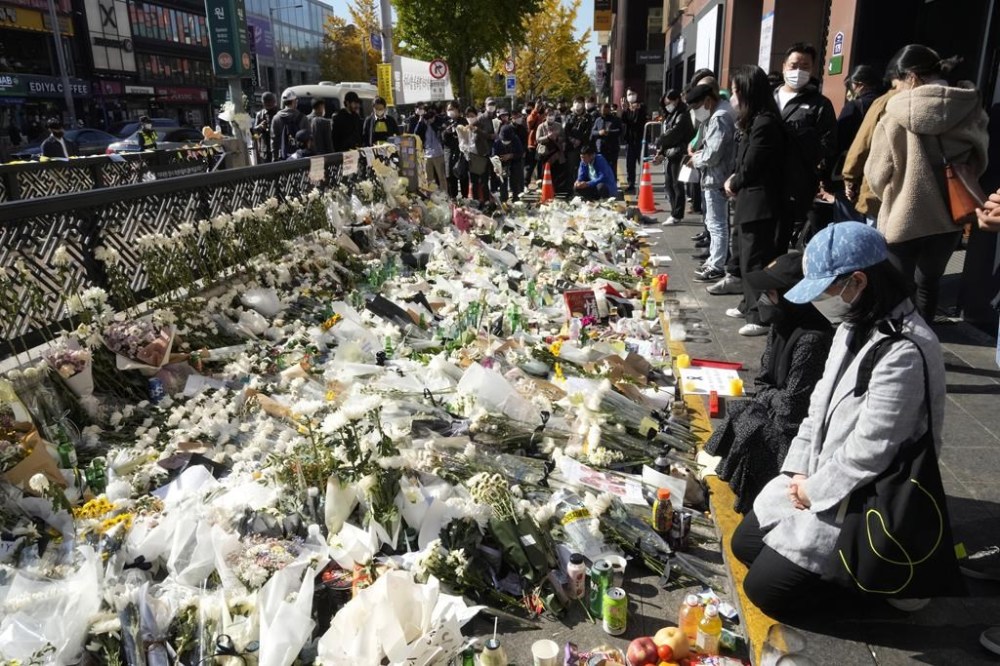 People pay tribute to victims of a deadly crowd crush during Saturday night's Halloween festivities, at a makeshift flower-laying area set up near the scene of the incident in Seoul, South Korea, Wednesday, Nov. 2, 2022. THE CANADIAN PRESS/AP-Ahn Young-joon