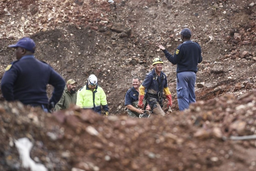 South African police investigate at the scene where more than 20 bodies, suspected of being illegal miners, were found near an active mine in Krugersdorp, South Africa, Thursday, Nov. 3, 2022. Police suspect that the bodies were moved to where they were found at a privately-owned mine. The grim discovery is the latest in a series of incidents related to illegal mining in the Krugersdorp area. (AP Photo)
