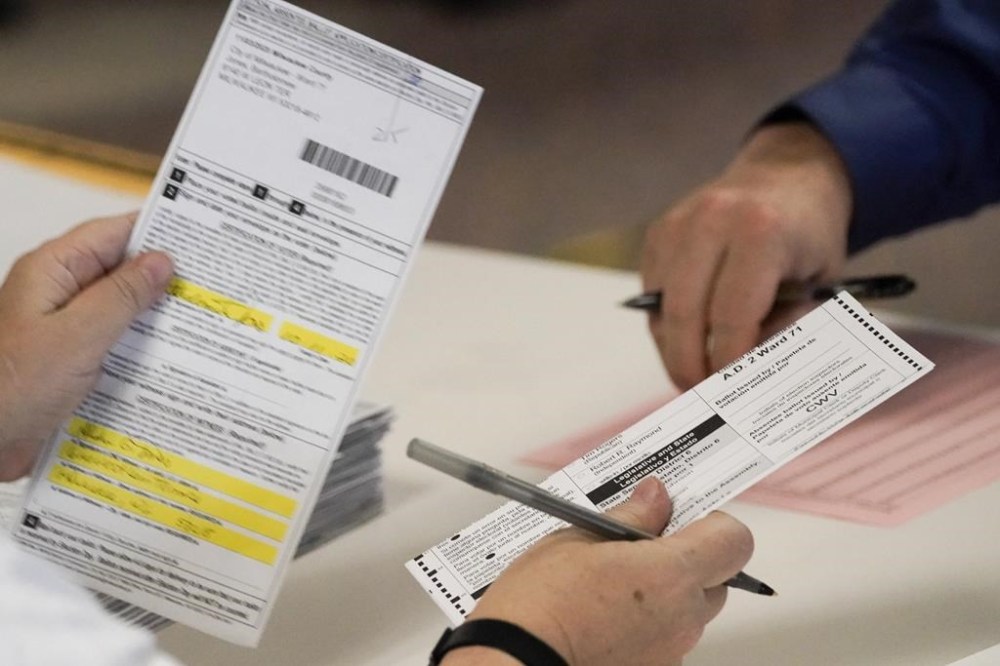 FILE - Workers count Milwaukee County ballots on Election Day at Central Count on Nov. 3, 2020, in Milwaukee. A top Milwaukee elections official has been fired after sending falsely obtained military absentee ballots to the home of a Republican state lawmaker who has been an outspoken critic of how the 2020 election was administered, the city's mayor said Thursday, Nov. 3, 2022. (AP Photo/Morry Gash File)