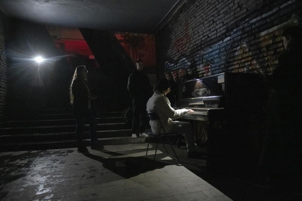A person plays a piano in a street underpass during a blackout in Kyiv, Ukraine, Sunday, Nov. 6, 2022. (AP Photo/Andrew Kravchenko)
