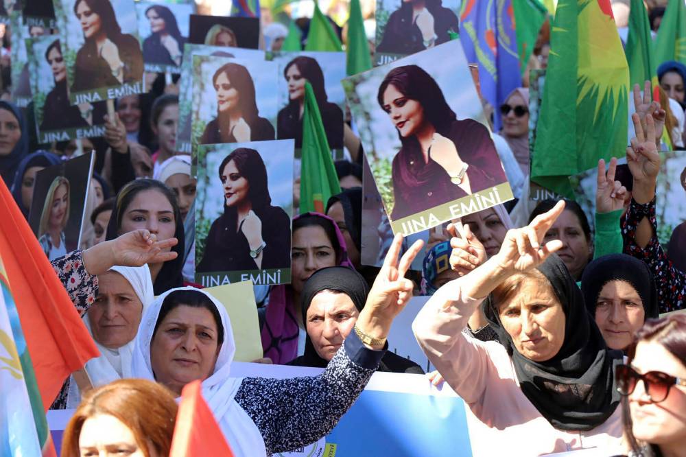 Hawar News Agency via AP
Kurdish women hold portraits of Mahsa Amini during a protest in northern Syria on Sept. 26. Protests erupted across Iran and in other countries after Amini, a 22-year-old Iranian woman, died while being held by that country’s morality police for violating the strictly enforced Islamic dress code.