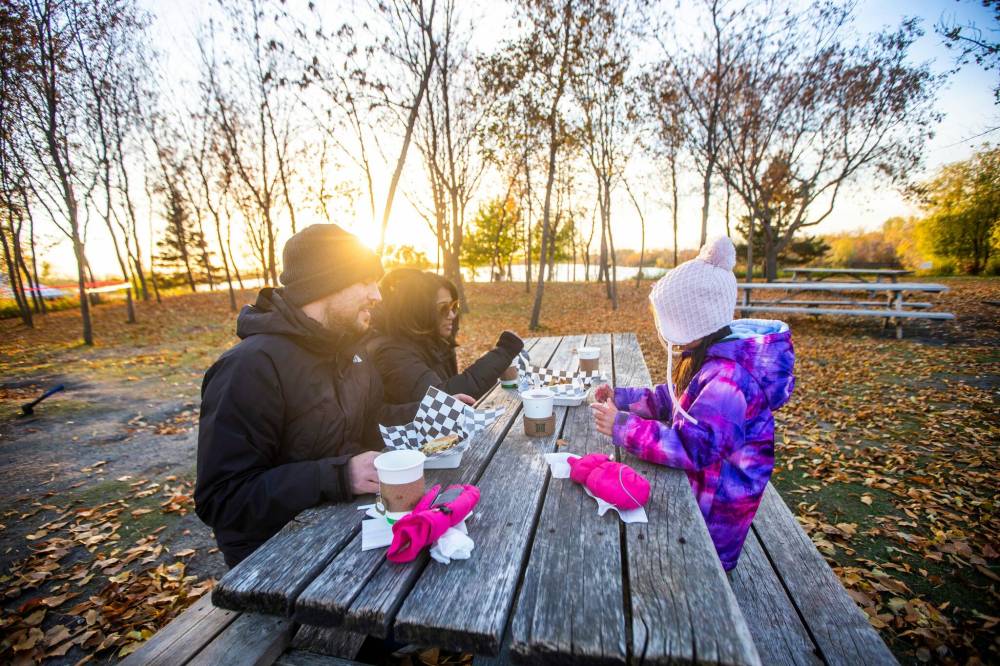 MIKAELA MACKENZIE / WINNIPEG FREE PRESS
Chris, AV, and Faith Kitching get poutine and hot drinks to keep chilly fingers warm while waiting for the sunset goose flight.