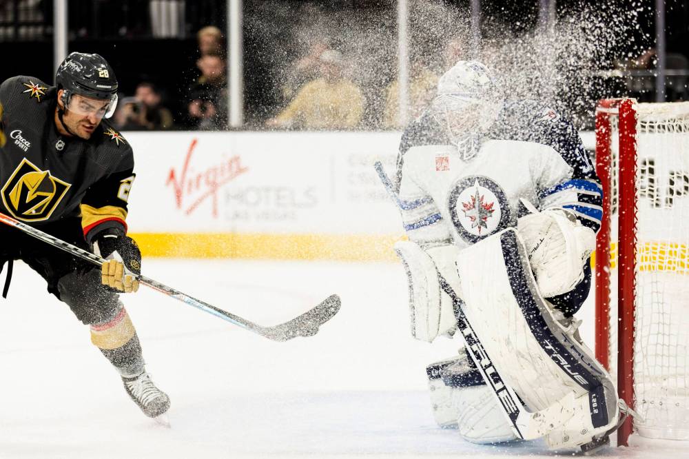 ELLEN SCHMIDT / THE ASSOCIATED PRESS
Vegas Golden Knights left wing William Carrier, left, takes a shot on goal against Winnipeg Jets goaltender Connor Hellebuyck during the second period in an NHL hockey game Sunday in Las Vegas.