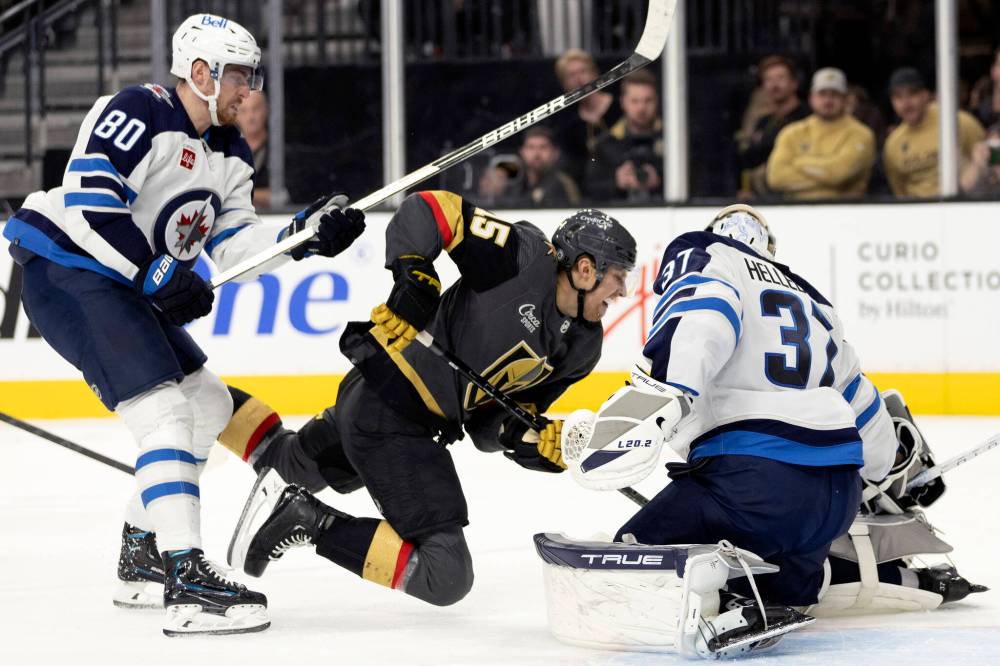 ELLEN SCHMIDT / THE ASSOCIATED PRESS
Vegas Golden Knights center Jake Leschyshyn dives to shoot against Winnipeg Jets goaltender Connor Hellebuyck while left wing Pierre-Luc Dubois defends during the second period.