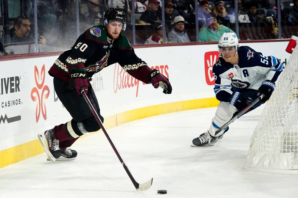 ROSS D. FRANKLIN / THE ASSOCIATED PRESS FILES
Arizona Coyotes defenceman J.J. Moser tries to keep the puck away from Winnipeg Jets centre Mark Scheifele, who scored the goal that tied the game 2-2 before Blake Wheeler won it for Winnipeg in overtime on Friday.