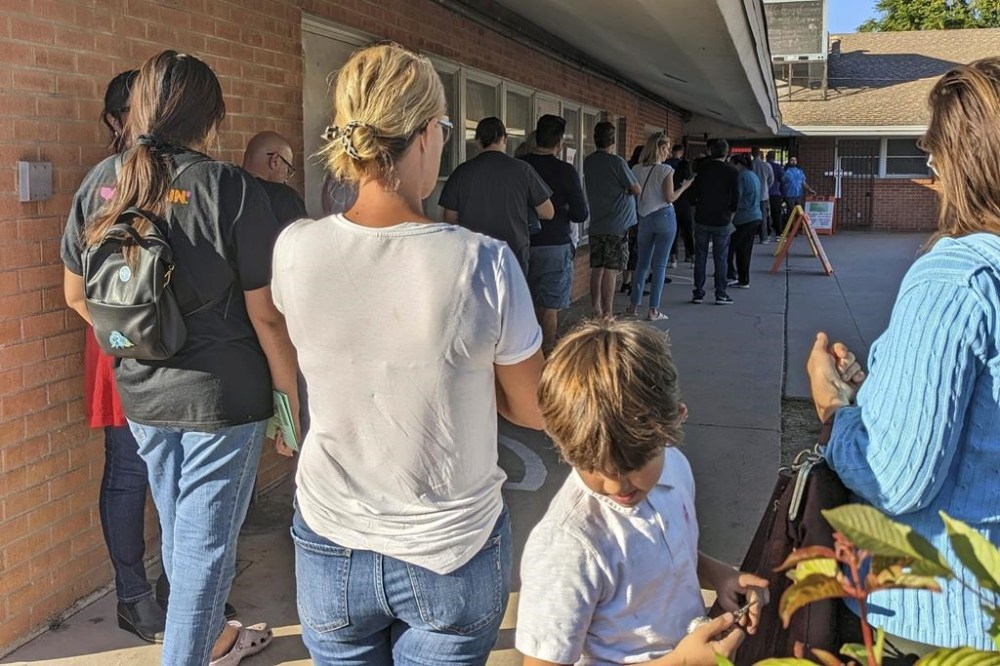 Voters wait to cast their ballots at Memorial Presbyterian Church, a busy polling place in central Phoenix, Tuesday, Nov. 8, 2022. Tabulator machines inside the polling site were having trouble reading ballots, causing long lines and additional delays to counting the voting. (AP Photo/Nathan Ellgren)