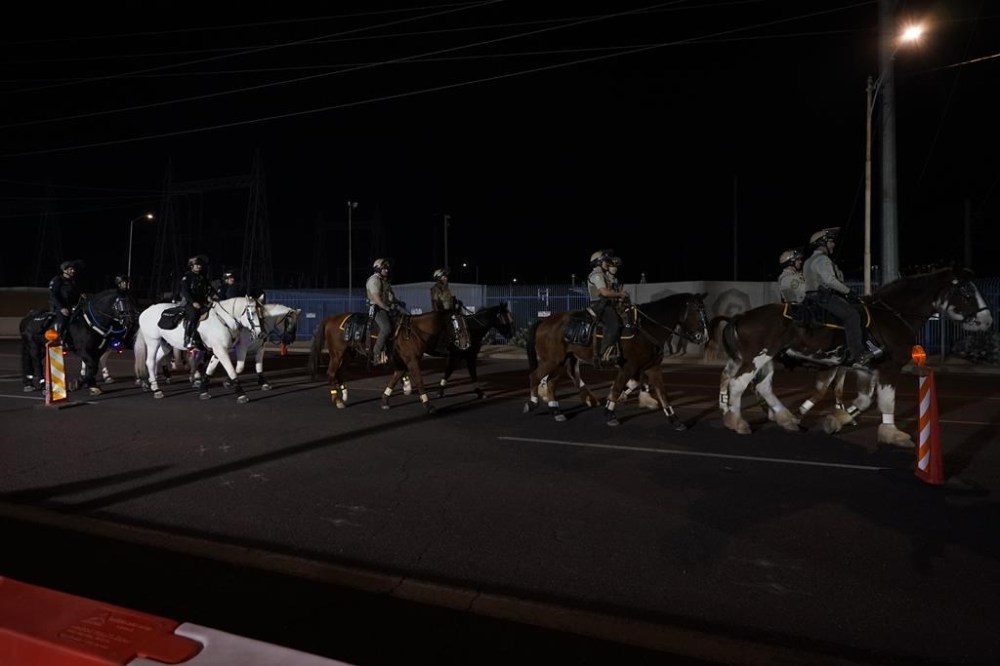 Law enforcement officers on horseback patrol the street outside the Maricopa County Recorders Office, Tuesday, Nov. 8, 2022, in Phoenix. (AP Photo/Matt York)