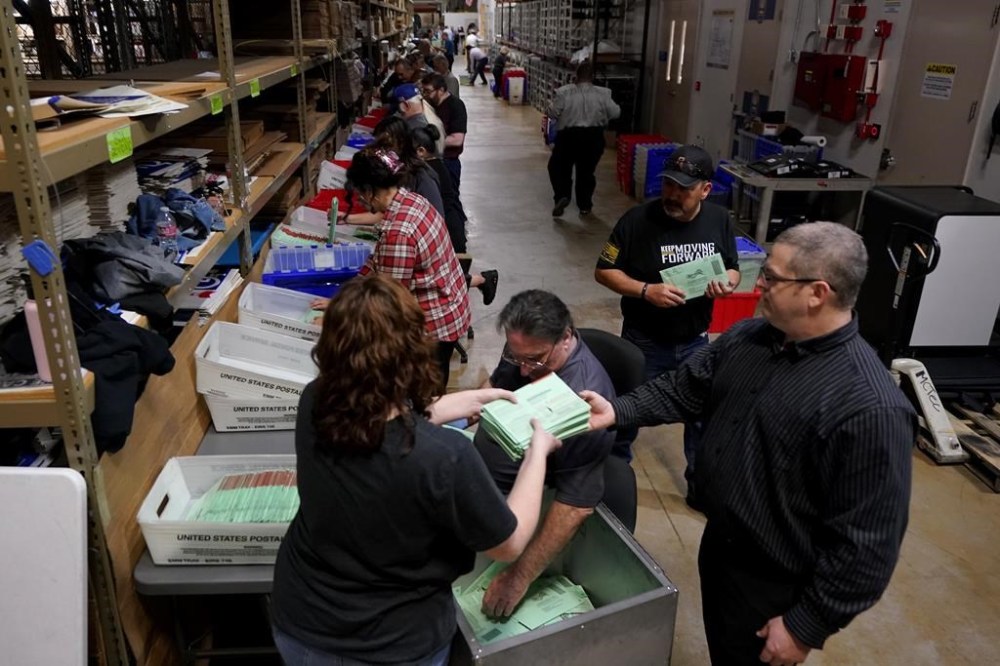Election workers sort early ballots for signature verification prior to tabulation inside the Maricopa County Recorders Office, Tuesday, Nov. 8, 2022, in Phoenix. (AP Photo/Matt York)