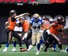 B.C. Lions quarterback Nathan Rourke (12) passes while being pressured by Winnipeg Blue Bombers' Jackson Jeffcoat (94) during the second half of CFL football game in Vancouver, on Saturday, July 9, 2022. THE CANADIAN PRESS/Darryl Dyck