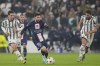 PSG's Lionel Messi, centre, runs with the ball past Juventus' Manuel Locatelli, right, and Juventus' Fabio Miretti during the Champions League group H soccer match between Juventus and Paris Saint Germain at the Allianz stadium in Turin, Italy, Wednesday, Nov. 2, 2022. (AP Photo/Antonio Calanni)