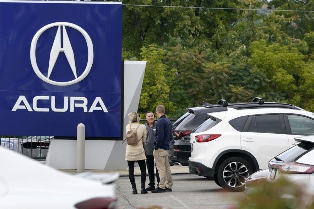 FILE - A salesman talks with customers at an Acura dealer in Wexford, Pa., on Sept. 29, 2022. The Federal Reserve may reach a turning point this week as it announces what's expected to be another substantial three-quarter-point hike in its key interest rate. The Fed's hikes have already led to much costlier borrowing rates, ranging from mortgages to auto and business loans. (AP Photo/Gene J. Puskar, File)