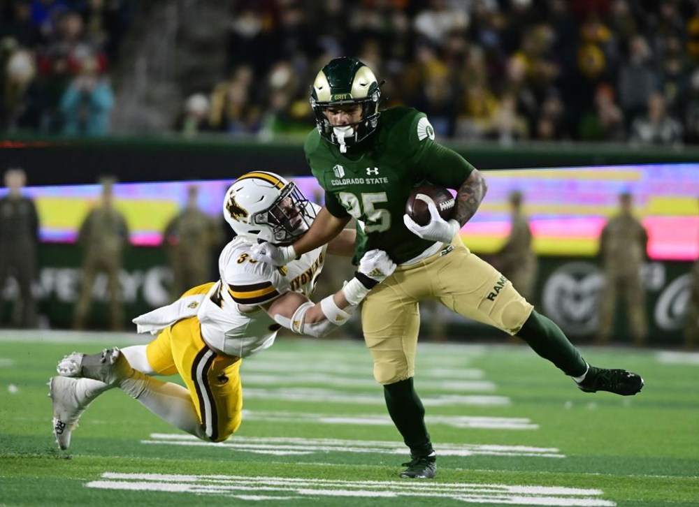Colorado State running back Avery Morrow (25) tries to get free from Wyoming linebacker Connor Shay (33) during the first quarter of an NCAA college football game Saturday, Nov. 12, 2022, in Fort Collins, Colo. (Andy Cross/The Denver Post via AP)