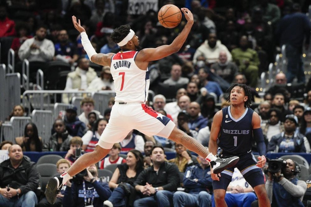 Washington Wizards guard Jordan Goodwin (7) reaches for a rebound against Memphis Grizzlies guard Kennedy Chandler (1) during the first half of an NBA basketball game, Sunday, Nov. 13, 2022, in Washington. (AP Photo/Jess Rapfogel)