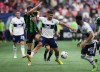 Vancouver Whitecaps' Lucas Cavallini, centre, and Austin FC's Jon Gallagher vie for the ball during the second half of an MLS soccer game in Vancouver, on Saturday, October 1, 2022. THE CANADIAN PRESS/Darryl Dyck