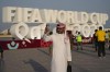 FILE - A man takes a selfie with a sign reading in English