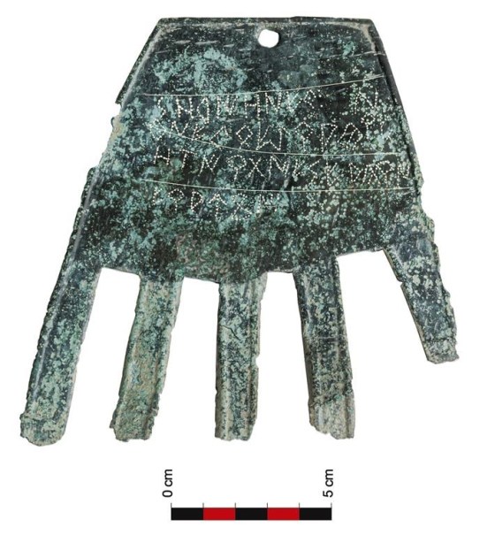 A flat piece of bronze shaped like a human hand is displayed in the Navarra region. (Sociedad de Ciencias Aranzadi via The Associated Press)