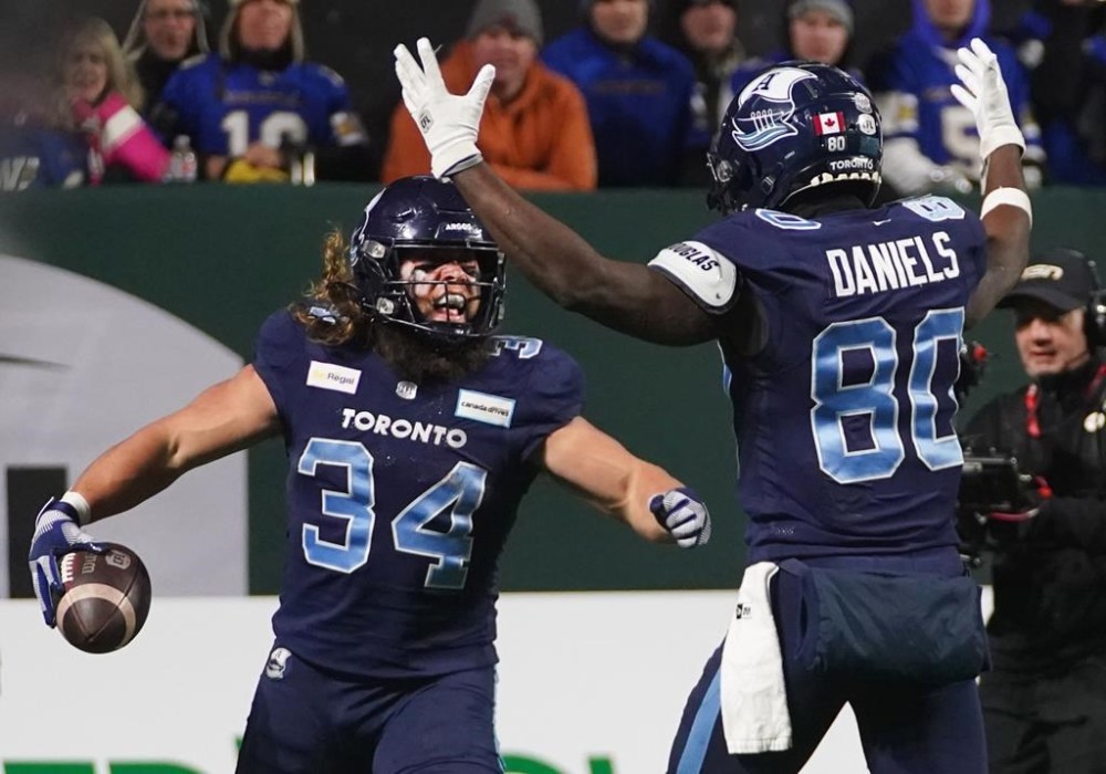 Toronto Argonauts running back AJ Ouellette (34) celebrates his touchdown with wide receiver DaVaris Daniels (80) during second half football action against the Winnipeg Blue Bombers in the 109th Grey Cup at Mosaic Stadium in Regina, Sunday, Nov. 20, 2022. Ouellette's five-yard touchdown run in the fourth quarter rallied the Toronto Argonauts to a stirring 24-23 upset of the Winnipeg Blue Bombers in the 109th Grey Cup on Sunday night. THE CANADIAN PRESS/Heywood Yu