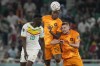 Denzel Dumfries of the Netherlands, center, jumps for a header with Senegal's Ismaila Sarr, left and Matthijs de Ligt of the Netherlands during the World Cup, group A soccer match between Senegal and Netherlands at the Al Thumama Stadium in Doha, Qatar, Monday, Nov. 21, 2022. (AP Photo/Ricardo Mazalan)