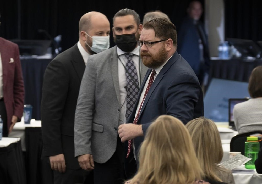 Security escort Freedom Corp. counsel Brendan Miller out of the hearing room at the Public Order Emergency Commission, in Ottawa, Tuesday, Nov. 22, 2022. Justice Paul Rouleau, the inquiry's commissioner, asked security to remove Miller from the hearing after Miller spoke over the commissioner and accused him of refusing to rule on similar applications. THE CANADIAN PRESS/Adrian Wyld