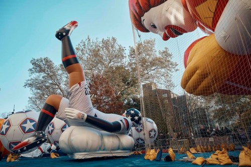 People watch at inflated helium balloons of Ronald McDonald and a football player on Wednesday, Nov. 23, 2022, in New York, as the balloon is readied for the Macy's Thanksgiving Day Parade on Thursday. (AP Photo/Andres Kudacki)