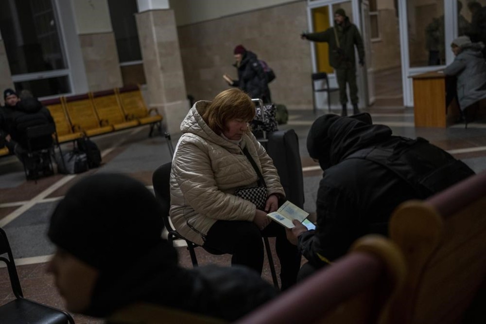 Ukrainian police conduct a security check on passengers before boarding the Kherson-Kyiv train at the Kherson railway station, southern Ukraine, Saturday, Nov. 26, 2022. Fleeing shelling, hundreds of civilians on Saturday streamed out of the southern Ukrainian city whose recapture they had celebrated just weeks earlier. (AP Photo/Bernat Armangue)