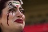An Iranian woman, name not given, breaks into tears after a member of security seized her flag reading 