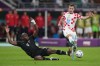 Canada defender Kamal Miller (4) dives to defend as Croatia defender Josip Juranovic (22) plays the ball during first half group F World Cup soccer action at the Khalifa International Stadium in Al Rayyan, Qatar on Sunday, November 27, 2022. THE CANADIAN PRESS/Nathan Denette