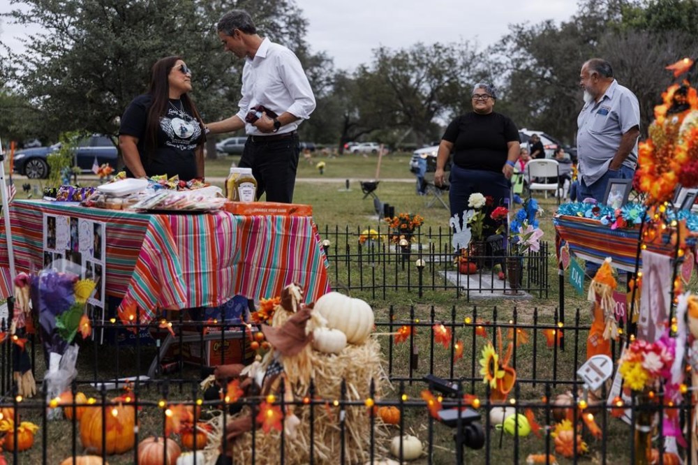 FILE - Sandra Cruz Torres, mother of Robb Elementary massacre victim Eliahna Torres, chats with Beto O'Rourke, Democratic candidate running for governor, as Cruz and her family celebrate Día de los Muertos at Torres' gravesite in Hillcrest Memorial Cemetery in Uvalde, Texas, Nov. 2, 2022. Sandra Cruz Torres filed a federal lawsuit on Monday, Nov. 28, against the police, the school district and the maker of the gun used in the massacre. (Sam Owens/The San Antonio Express-News via AP, File)