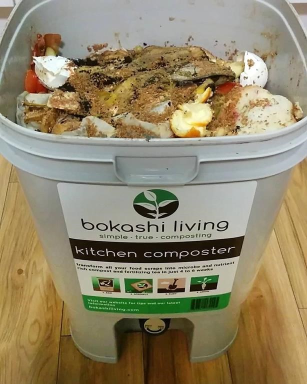 This image provided by Bokashi Living shows layers of kitchen scraps covered with a sprinkling of bran inoculant in a specialized composting bucket. (bokashiliving.com via AP)