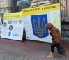 A person walks past signage in downtown Kyiv, Ukraine on Thursday Nov. 29, 2022. Residents of Kyiv waited with patience and resignation Tuesday as all signs pointed toward another imminent Russian bombing of their city. THE CANADIAN PRESS/Patrice Bergeron