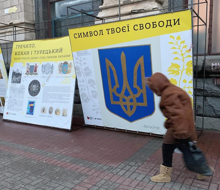 A person walks past signage in downtown Kyiv, Ukraine on Thursday Nov. 29, 2022. Residents of Kyiv waited with patience and resignation Tuesday as all signs pointed toward another imminent Russian bombing of their city. THE CANADIAN PRESS/Patrice Bergeron
