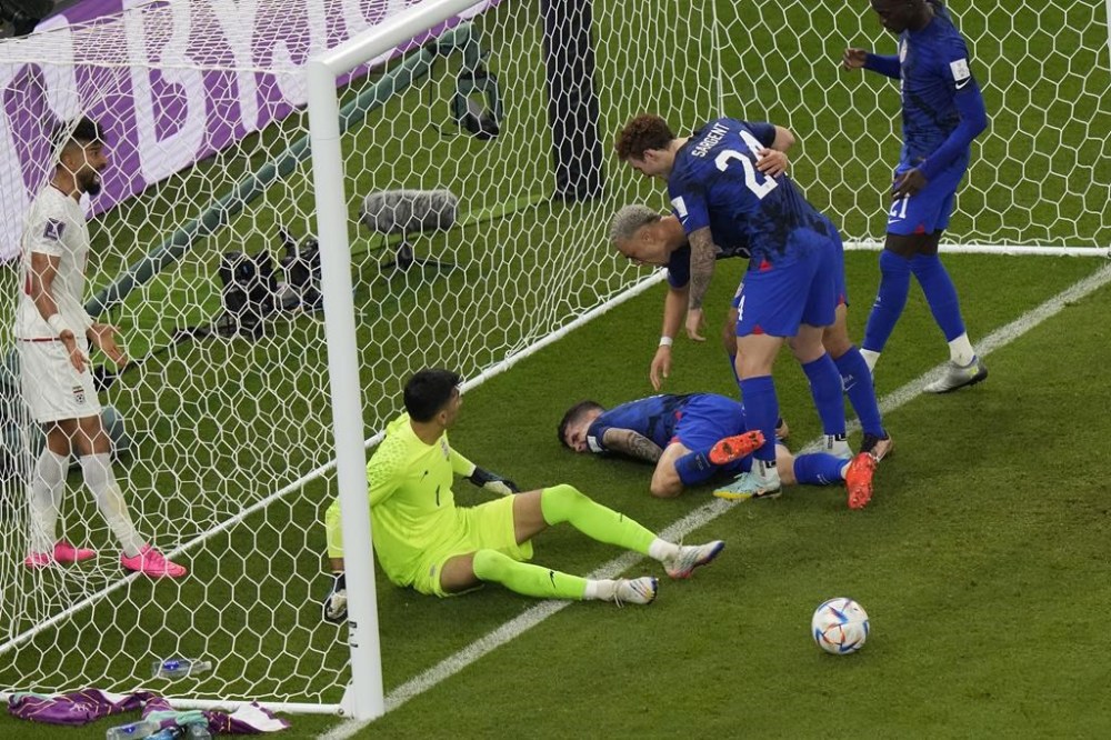 Christian Pulisic of the United States lays injured on the pitch after he scoring his side's opening goal during the World Cup group B soccer match between Iran and the United States at the Al Thumama Stadium in Doha, Qatar, Tuesday, Nov. 29, 2022. (AP Photo/Luca Bruno)