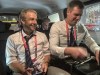Juergen Klinsmann, left, sits in a car as he records a podcast after the World Cup group C soccer match between Poland and Argentina at the Stadium 974 in Doha, Qatar, Wednesday, Nov. 30, 2022. (AP Photo/Graham Dunbar)