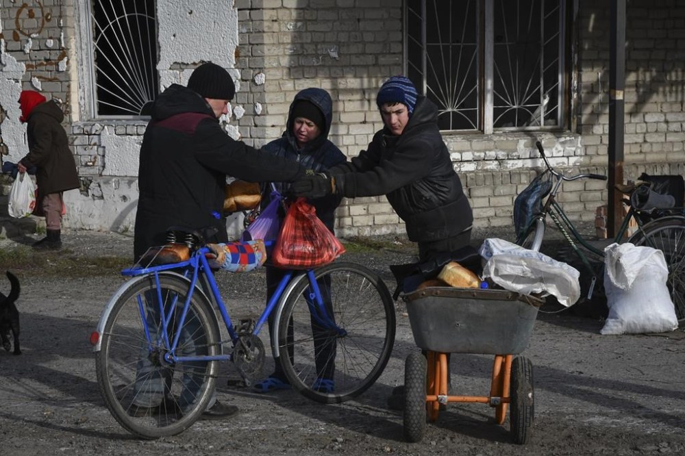 Local resident receive a food at a mobile humanitarian aid point in the village of Zarichne, Donetsk region, Ukraine, Friday, Dec. 2, 2022. (AP Photo/Andriy Andriyenko)