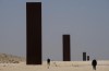 People overlook famous American artist Richard Serra's 'East-West/West-East' art as it stands in a desolate section of the Brouq nature reserve in the northwestern part of the country's desert close to Zekreet, Qatar on Saturday, December 3, 2022. Four steel plates, each 14 metres high, span a one-kilometer stretch of the desert. THE CANADIAN PRESS/Nathan Denette