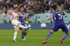 Croatia's Luka Modric, left, kicks the ball ahead of Japan's Hidemasa Morita, centre, and Japan's Shogo Taniguchi during the World Cup round of 16 soccer match between Japan and Croatia at the Al Janoub Stadium in Al Wakrah, Qatar, Monday, Dec. 5, 2022. (AP Photo/Thanassis Stavrakis)
