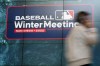 A man passes a display during the Major League Baseball winter meetings, Tuesday, Dec. 6, 2022, in San Diego. (AP Photo/Gregory Bull)