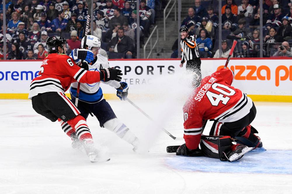 FRED GREENSLADE / THE CANADIAN PRESS
Chicago Blackhawks’ goaltender Arvid Soberblom (40) covers the puck as Winnipeg Jets’ Mark Scheifele (55) and Jake McCabe (6) chase the puck during the second period.
