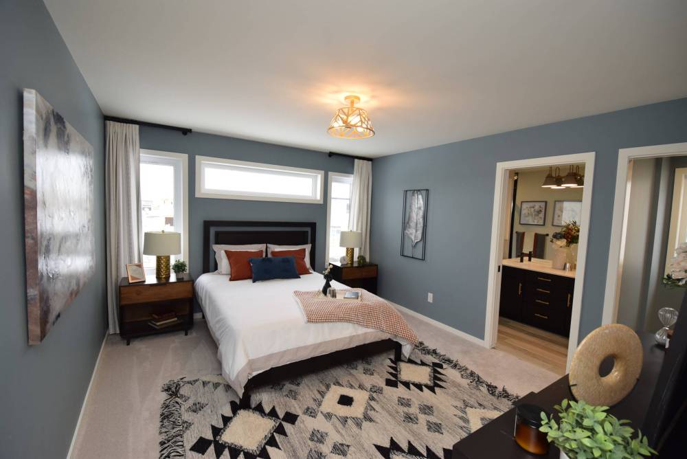 Soft earth tones, an abundance of natural light and ample space to move about make the isolated primary bedroom a relaxing retreat.