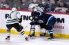 Neal Pionk fights for the puck along the boards with Miro Heiskanen and Joe Pavelski during the third period on Tuesday. (Fred Greenslade / The Canadian Press)