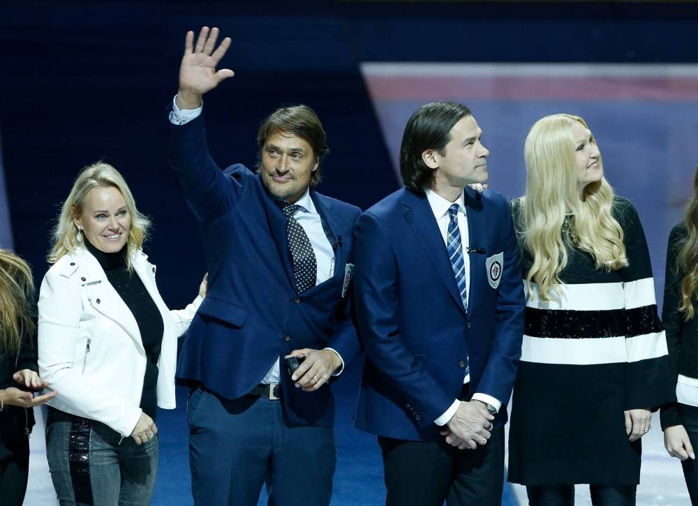 Teemu Selanne waves to the crowd during a ceremony where he and Teppo Numminen (right) were inducted into the Winnipeg Jets Hall of Fame prior to the start of Thursday's game. (John Woods / The Canadian Press)