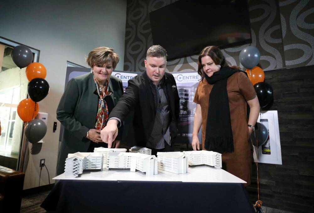 City coun. Janice Lukes (from left), Tim Comack, Ventura Developments VP and Premier Heather Stefanson check out plans for the proposed development. (Ruth Bonneville / Winnipeg Free Press)
