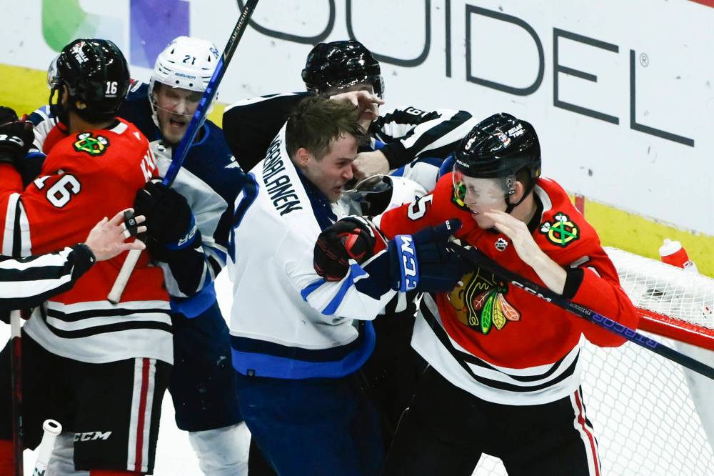Winnipeg Jets right winger Saku Maenalanen, centre, and Chicago Blackhawks defenceman Connor Murphy engage in some rough stuff during the third period Sunday in Chicago. (AP Photo/Matt Marton)