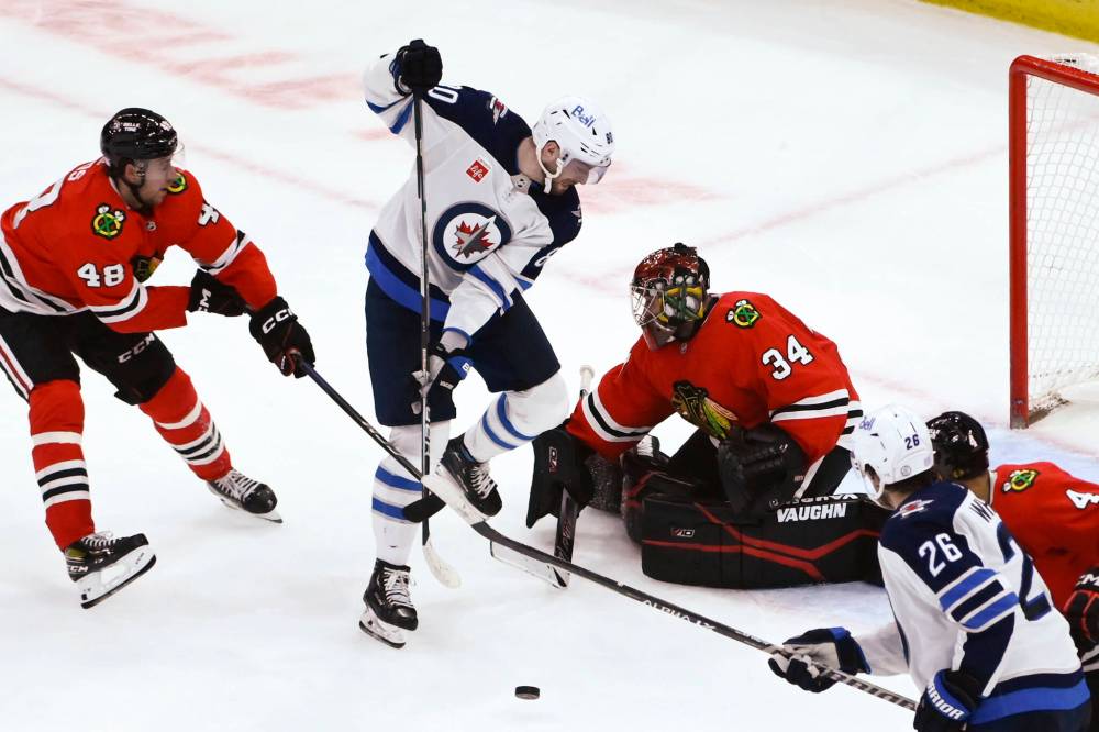 Winnipeg Jets centre Pierre-Luc Dubois (80) works the puck past Chicago Blackhawks defenceman Filip Roos (48) and goaltender Petr Mrazek (34) during the third period Sunday in Chicago. (AP Photo/Matt Marton)