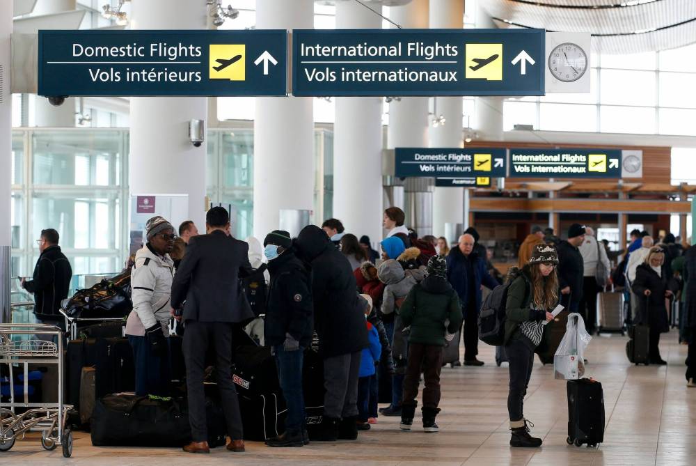 JOHN WOODS / WINNIPEG FREE PRESS
Travellers gather at Winnipeg’s airport as they try to board flights out of town Sunday. Air companies have been struggling with delays and cancellations due to weather.